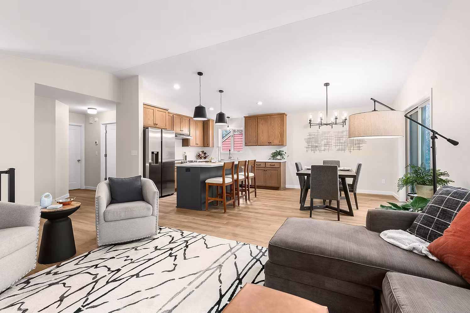 Open concept living room and kitchen with vaulted ceiling and area rug
