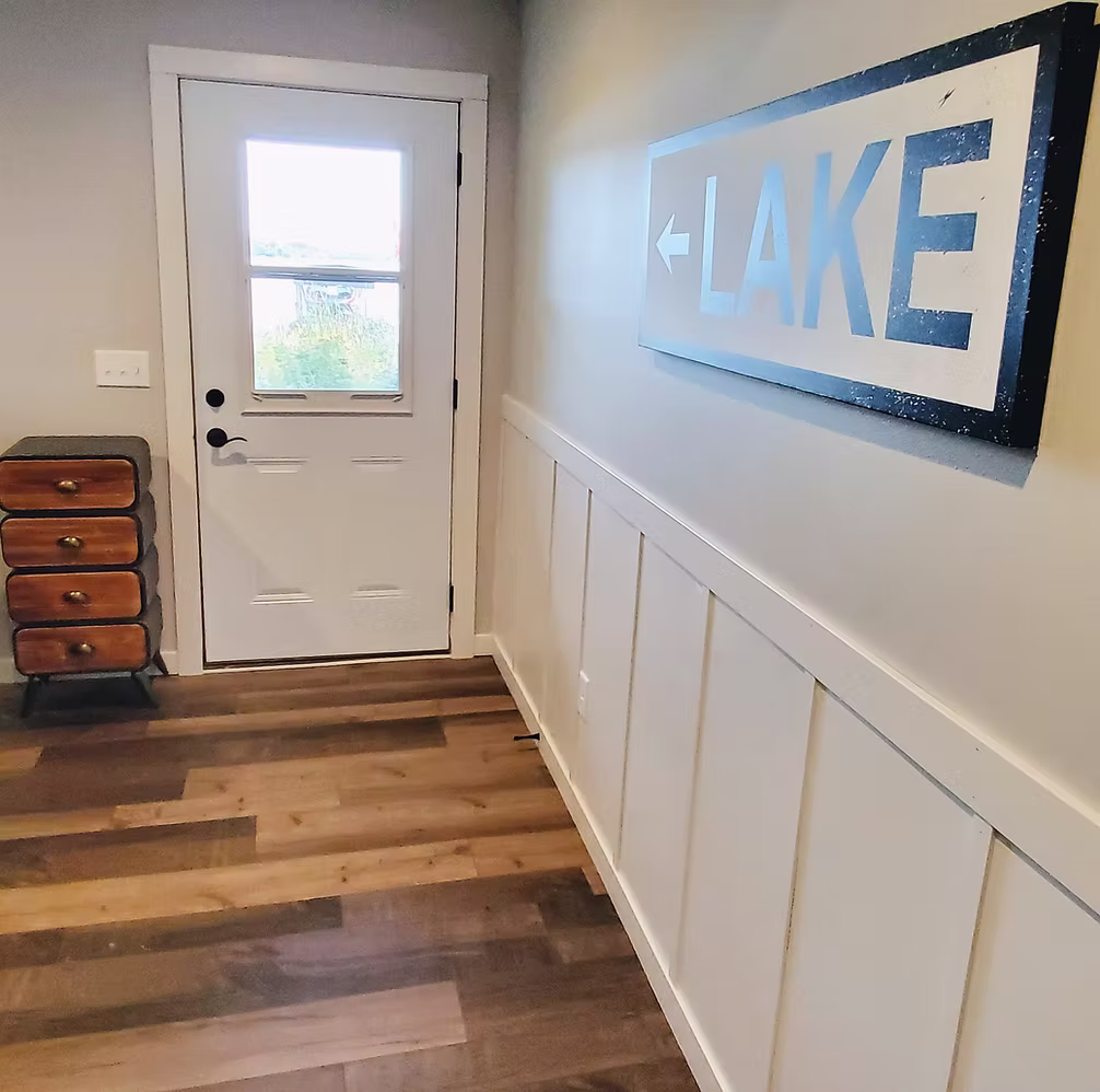 Entryway with board and batten wainscoting and dark hardwood floors