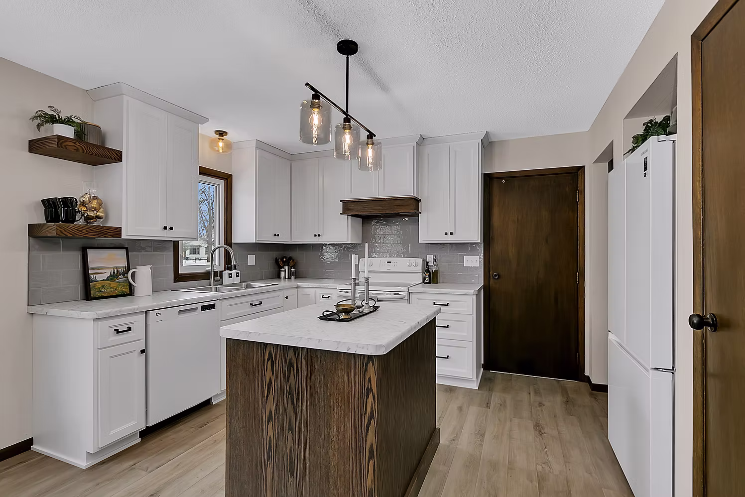 White kitchen with center island, open shelving, and pendant lights