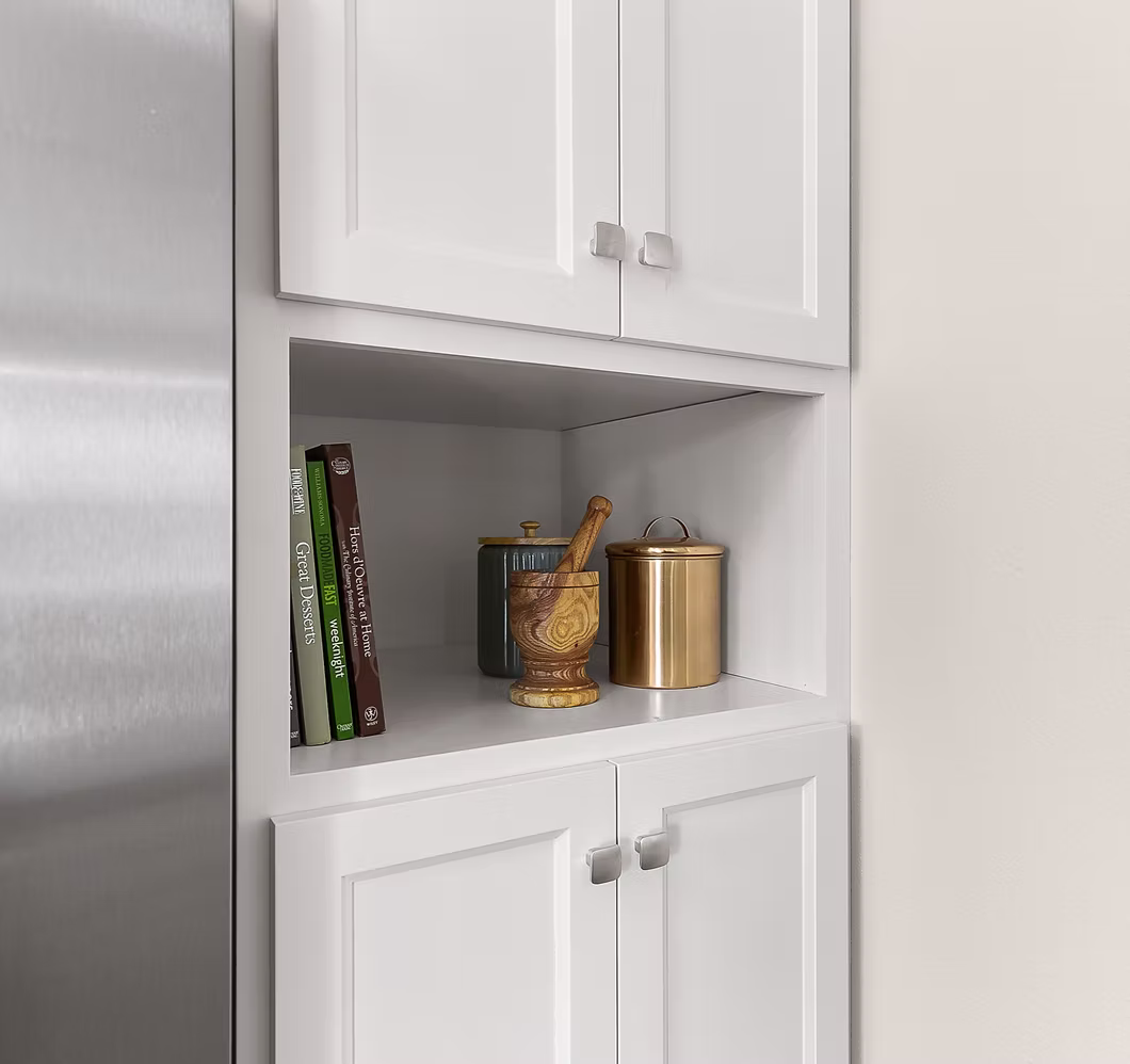 Kitchen built-in nook with white shaker cabinets flanking the refrigerator