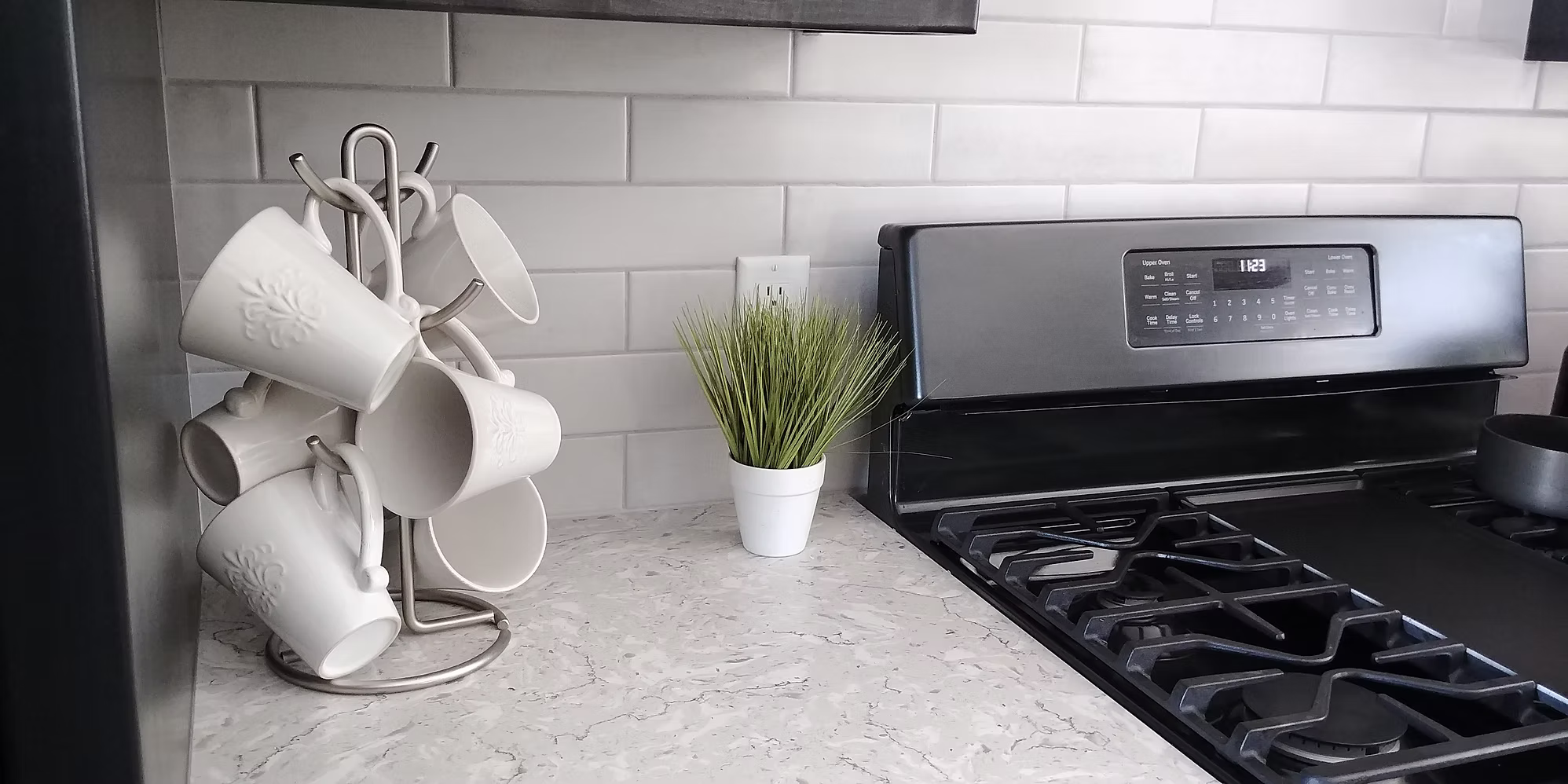 Kitchen counter detail with white subway tile backsplash and gas range