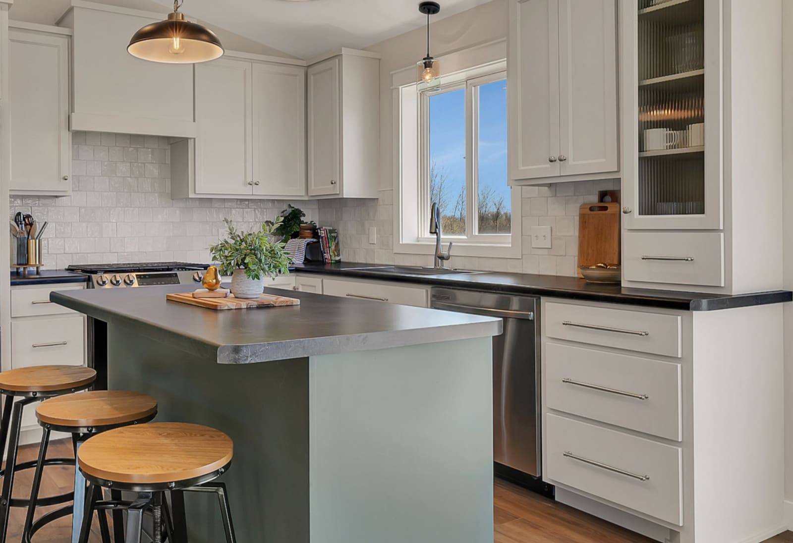 Beautiful kitchen remodel by Simply Enhanced Homes in Central Minnesota — white shaker cabinets, dark countertops, green island