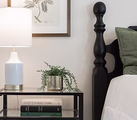 Interior design room styling — dark headboard, white lamp, layered textiles — Simply Enhanced Homes Central Minnesota