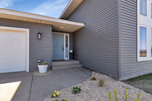 Exterior details — accent front door color, added landscaping, updated exterior lighting — Foley, MN remodel by Simply Enhanced Homes