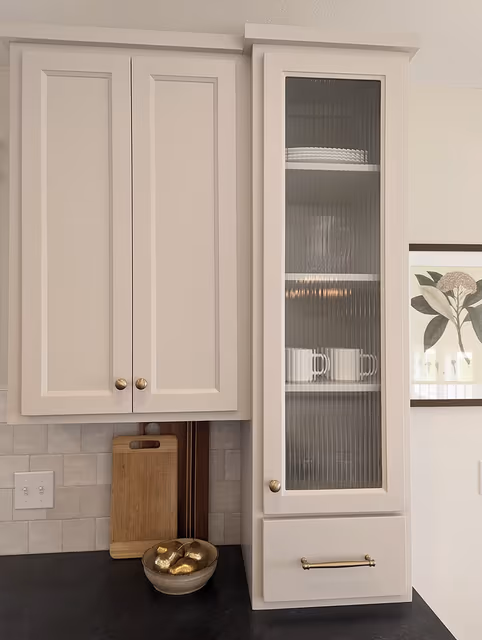 Kitchen details — brushed brass hardware, reeded glass, mushroom-colored cabinetry with dark countertops — Foley, MN remodel by Simply Enhanced Homes