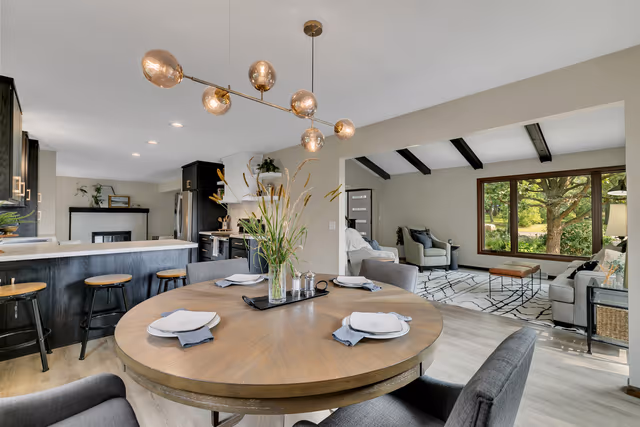 Dining — modern linear chandelier overlooking kitchen and living room — St. Cloud, MN remodel by Simply Enhanced Homes